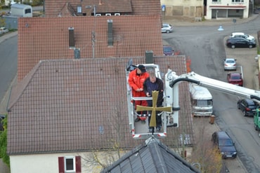 Das Kreuz auf dem Kirchenschiff wird montiert