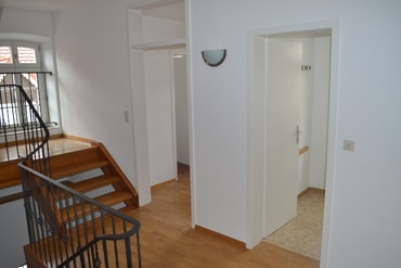 Vorraum der Wohnung im Ersten Stock mit Zugängen zum Vorratsraum und zum Gäste-WC und mit der Treppe ins Dachgeschoss