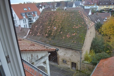 Blick aus einem Dachgeschossfenster zum Hof und zum Pfarrgarten
